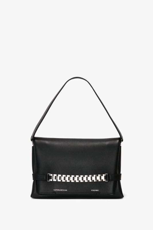 A Chain Pouch Bag with Brushed Silver Chain In Black Leather by Victoria Beckham, featuring a single handle and a brushed silver chain detail on the front, and a detachable strap for versatile styling.