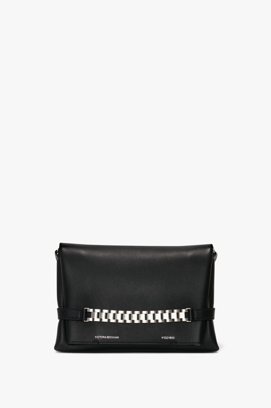 A black leather Chain Pouch Bag with Brushed Silver Chain In Black Leather featuring a brushed silver chain detail on the front and a detachable strap for versatile styling by Victoria Beckham.