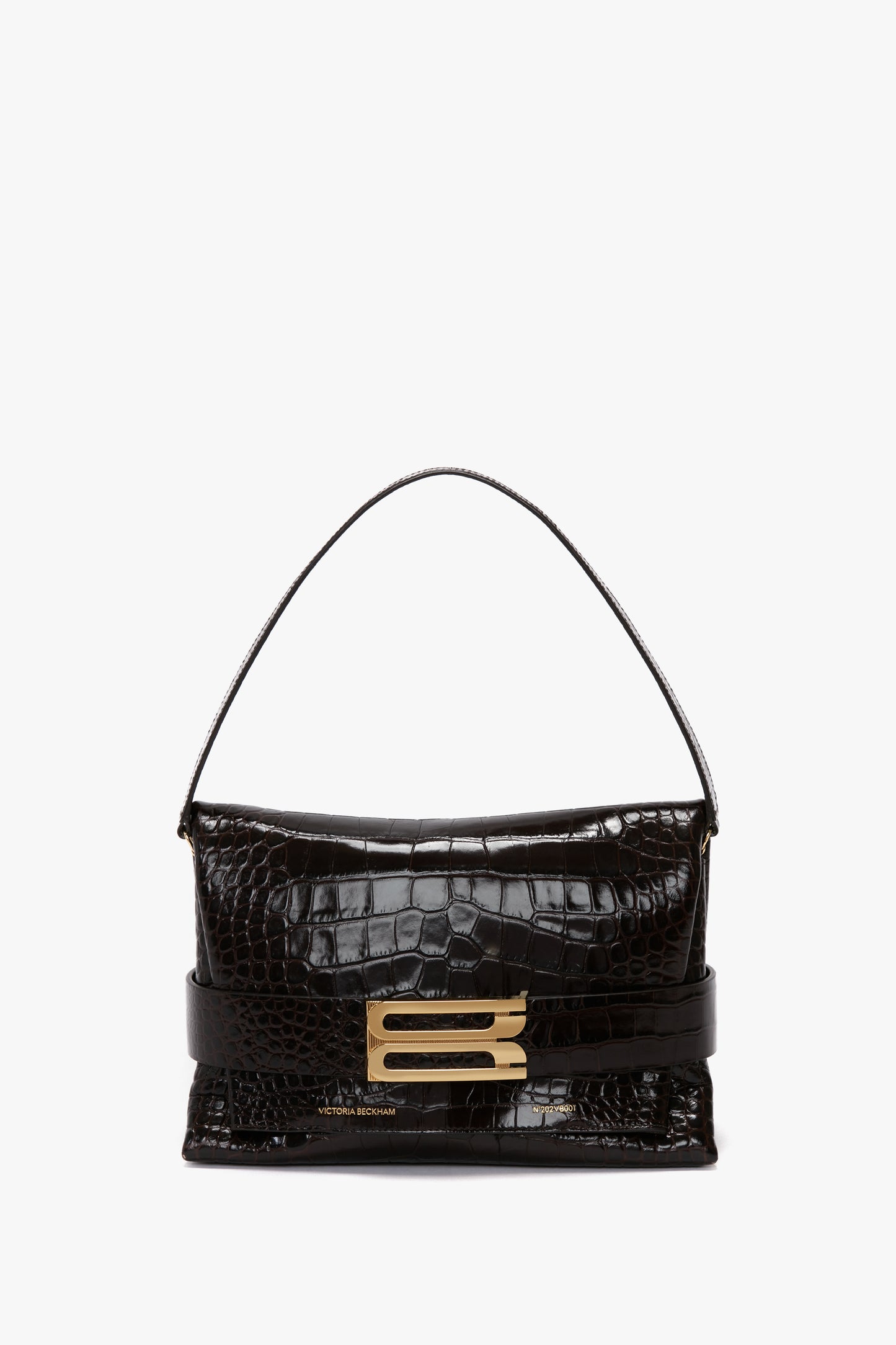 A black, calf leather B Pouch Bag In Croc Effect Espresso Leather by Victoria Beckham featuring an embossed crocodile print and a single strap with a gold buckle clasp is displayed against a plain white background.