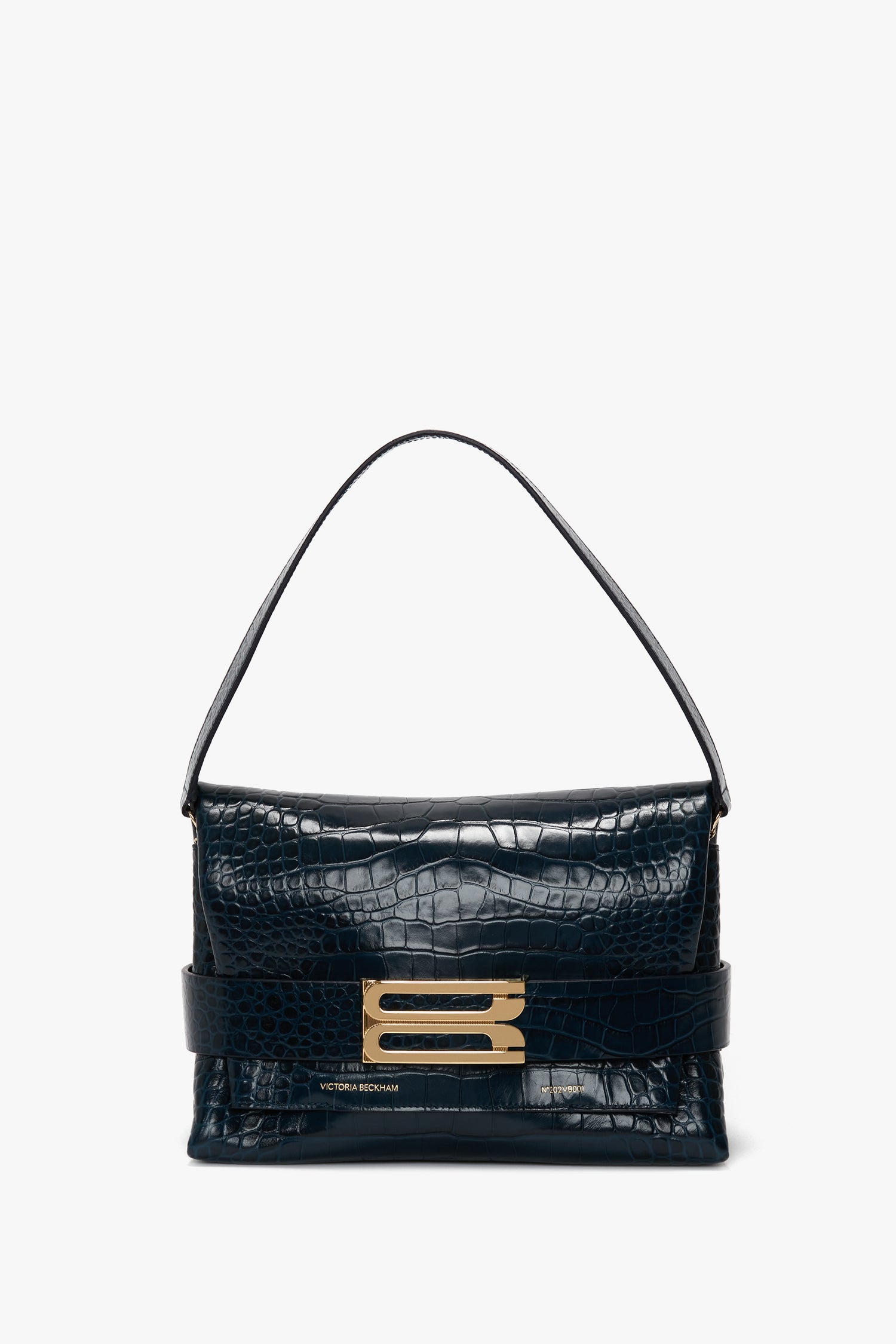 A chic B Pouch Bag In Croc Effect Midnight Blue Leather crafted from luxurious calf leather by Victoria Beckham, featuring an embossed crocodile print, a single strap, and a rectangular gold-tone buckle on the front.