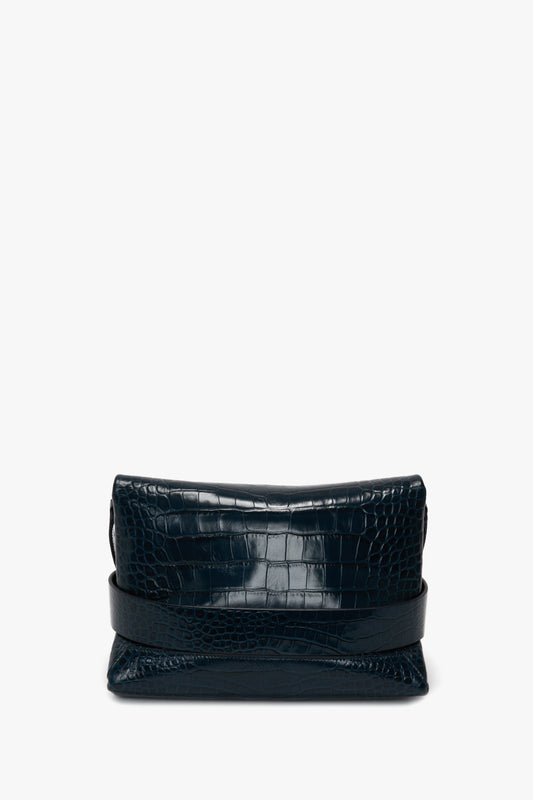 A Victoria Beckham B Pouch Bag In Croc Effect Midnight Blue Leather featuring an embossed crocodile print and a fold-over top, complete with a detachable shoulder strap.