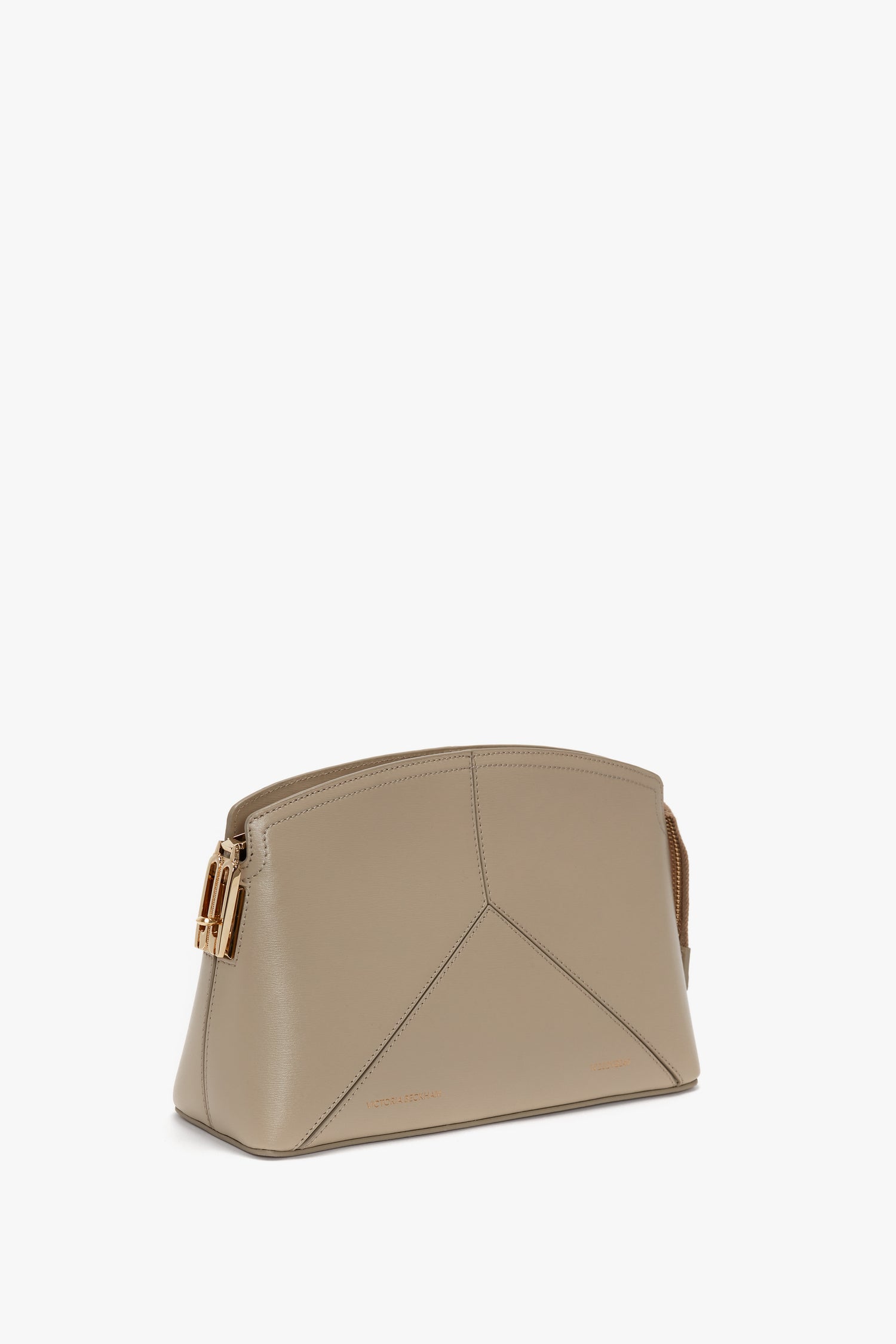 A Victoria Crossbody Bag In Taupe Leather with a structured design and gold-tone hardware, reminiscent of Victoria Beckham's elegant touch.