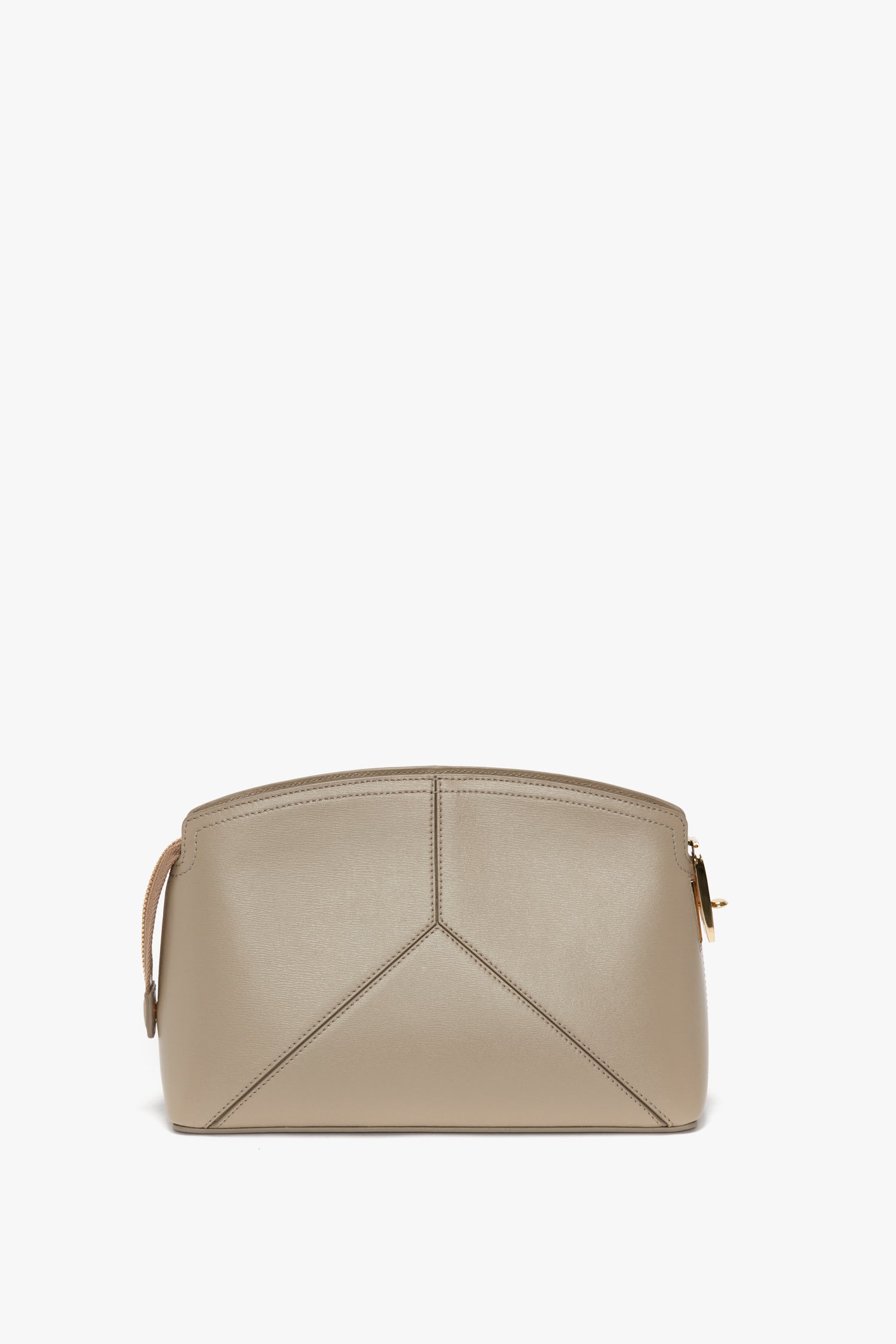 Beige, structured handbag with a geometric design, featuring a rounded top and gold hardware on the zippers. This Victoria Beckham Victoria Crossbody Bag In Taupe Leather marries elegance with modern functionality.