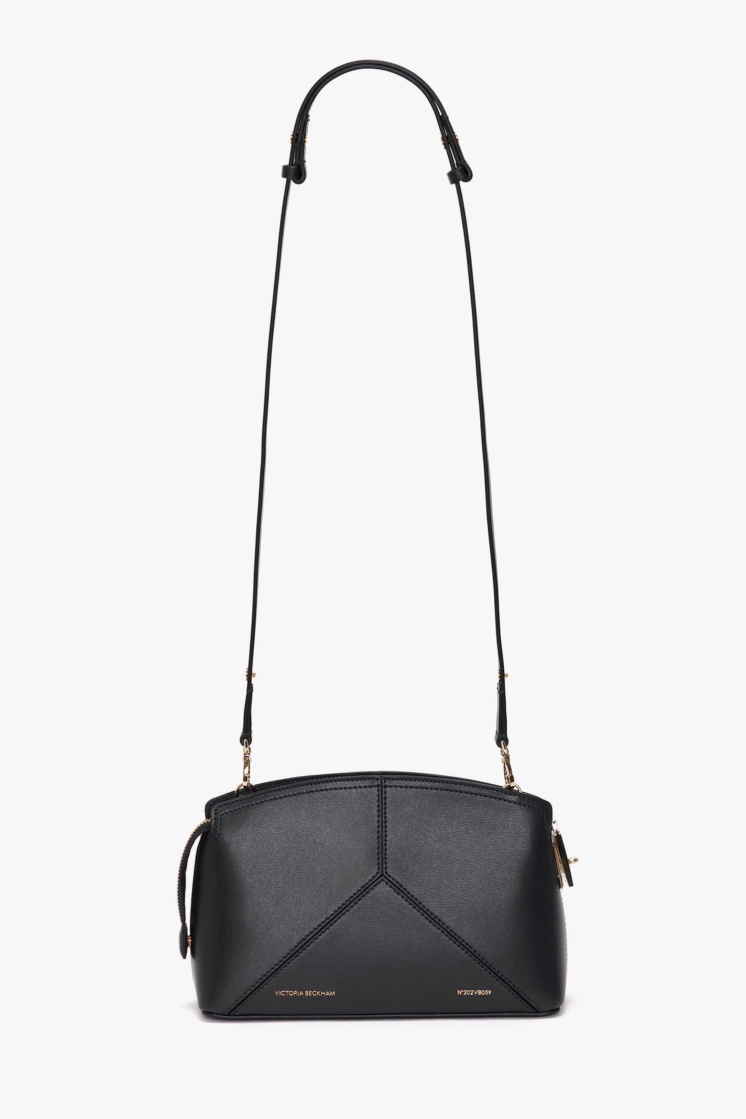 A Victoria Beckham Victoria Crossbody Bag In Black Leather in textured calf leather with gold accents, featuring a geometric design on the front and an adjustable shoulder strap.