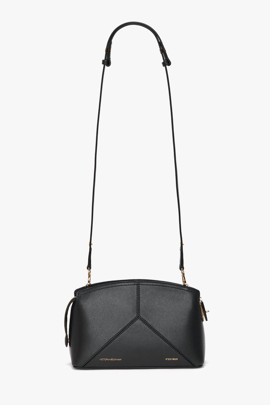 A Victoria Beckham Victoria Crossbody In Black Leather in textured calf leather with a geometric design and adjustable removable strap, featuring gold-tone hardware and branding on the front.