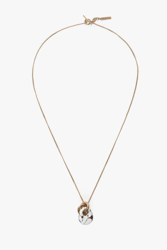 A Victoria Beckham Exclusive Resin Pendant Necklace In Light Gold-White with a 31cm-long delicate chain, featuring a white pendant with black accents and an additional small light gold ring near the pendant.