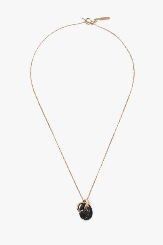 Sure, here is the revised sentence:  

The Exclusive Resin Pendant Necklace In Light Gold-Black by Victoria Beckham, a thin gold necklace featuring a delicate black resin pendant and a gold ring, crafted from 100% brass. Light Gold/Black finish enhances its elegance.