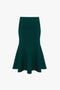 A dark green, high-waisted VB Body Flared Skirt In Lurex Green with a flattering flared silhouette and a smooth texture, displayed on a plain white background by Victoria Beckham.