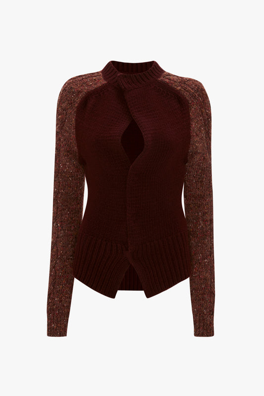 A Victoria Beckham Exclusive Contrast Sleeve Cardigan In Rust with a high neck, featuring cable-knit sleeves and long sleeves. The front showcases wavy, asymmetric detailing, adding a unique touch to this cozy piece.