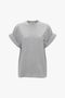 A plain, light grey Asymmetric Relaxed Fit T-Shirt In Grey Marl by Victoria Beckham in organic cotton with short rolled sleeves against a white background, reminiscent of Victoria Beckham's relaxed fitted style.