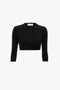 The Victoria Beckham VB Body Cropped Cardigan In Black features a form-fitting silhouette with a round neckline and button-down front, blending comfort with feminine sensibility.