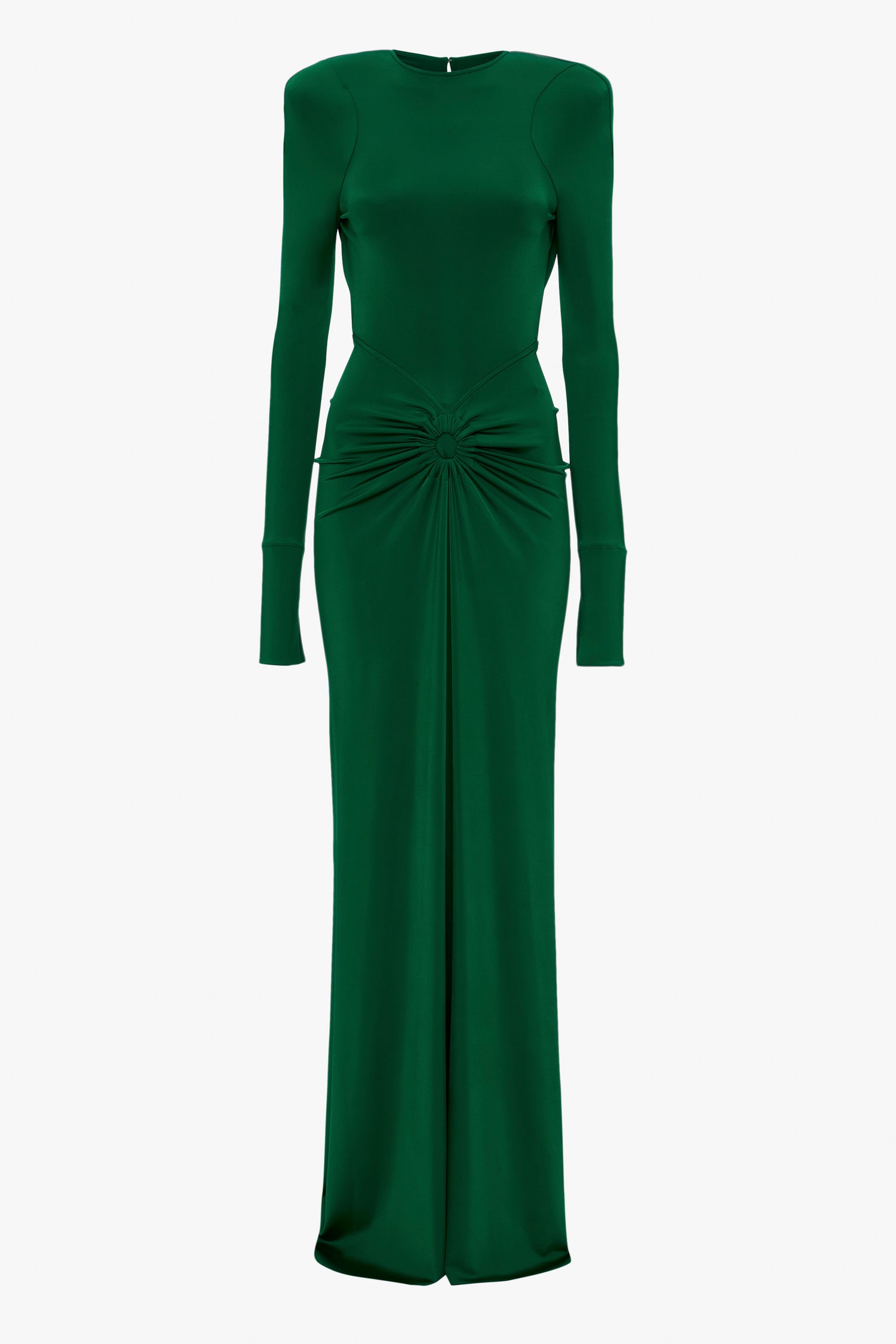 Victoria Beckham's Circle Detail Open Back Gown In Emerald is a green long-sleeve gown crafted from jersey fabric with shoulder pads and a gathered design at the waist. The dress is floor-length with an exposed back and a fitted silhouette.