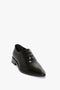 A single Pointy Toe Flat Lace Up In Black Brushed Leather shoe by Victoria Beckham with a pointy toe silhouette and low heel, crafted from brushed leather, set against a plain white background.