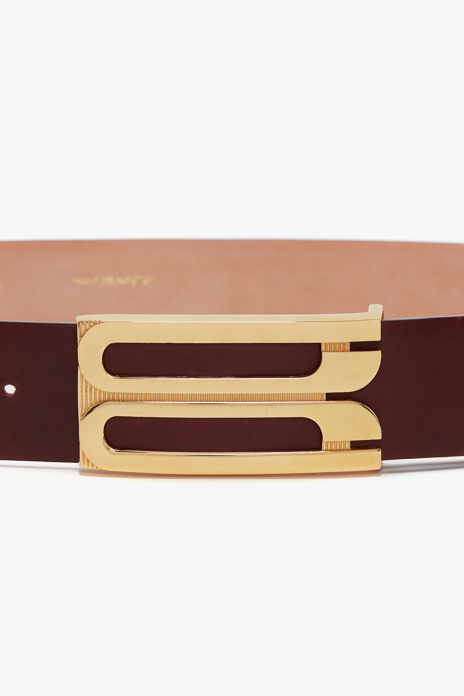 A Jumbo Frame Belt In Burgundy Leather from Victoria Beckham with distinctive gold hardware featuring two parallel rectangular slots.