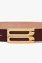 A Jumbo Frame Belt In Burgundy Leather from Victoria Beckham with distinctive gold hardware featuring two parallel rectangular slots.