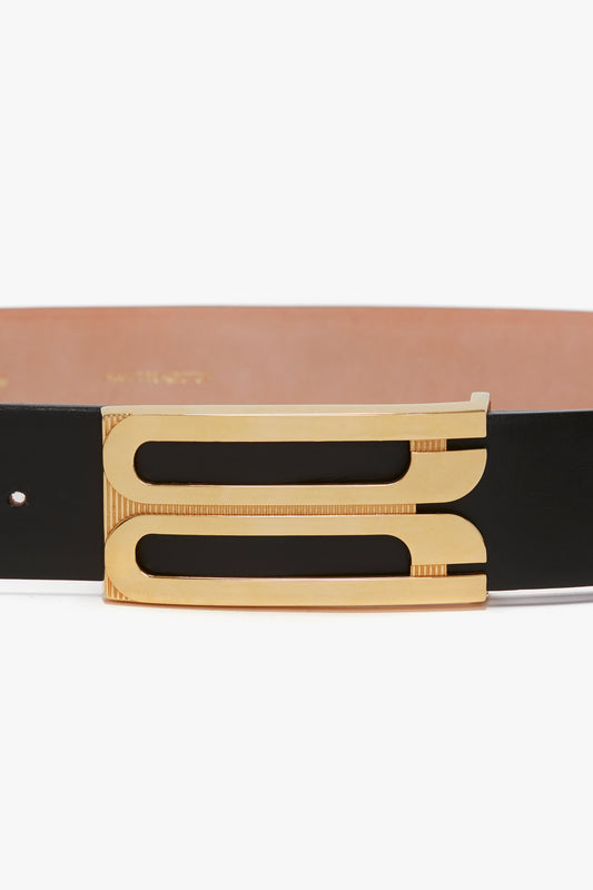 A contemporary belt crafted from smooth calf leather, featuring an ornate gold buckle with two parallel rectangular designs. The Jumbo Frame Belt In Black Leather by Victoria Beckham exemplifies this style.