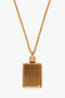 Exclusive Perfume Bottle Necklace In Brushed Gold hanging on a medium-length chain against a white background, reminiscent of a vintage perfume bottle pendant necklace from the Victoria Beckham collection.