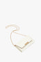 A small white Victoria Beckham Exclusive Wallet On Chain In White Leather crafted with a gold chain strap and gold clasp, placed against a white background.