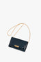 A Victoria Beckham Wallet On Chain In Midnight Croc-Effect Leather with a gold removable chain strap and clasp closure, placed on a white background.