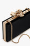 Frame Flower Minaudiere Bag in Black by Victoria Beckham, featuring a decorative flower clasp and a detachable shoulder strap.