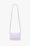 A minimalist Victoria Beckham Exclusive Mini Chain Pouch Bag With Long Strap In Lilac Leather is shown against a white background.