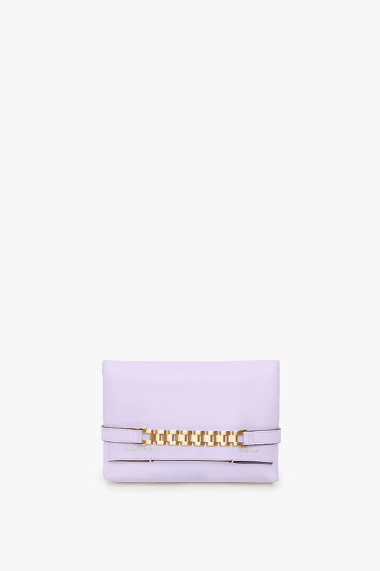 A small, lilac EXCLUSIVE Mini Chain Pouch With Long Strap In Lilac Leather by Victoria Beckham with gold chain detailing on the front and a detachable strap, set against a plain white background.
