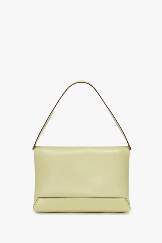 A light yellow Victoria Beckham Chain Pouch With Strap In Avocado Leather with a single shoulder strap and a minimalist design, displayed against a white background.