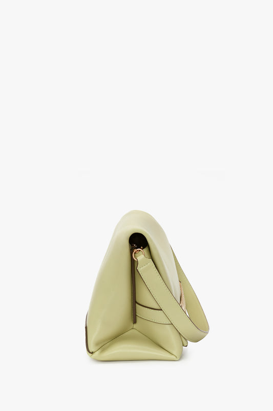 Side view of a small, avocado-green Chain Pouch With Strap In Avocado Leather with a single strap and a minimalist design, reminiscent of Victoria's style, against a white background. Brand Name: Victoria Beckham
