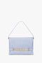 A light blue Victoria Beckham Chain Pouch With Strap In Frost Ostrich-Effect Leather with an embossed ostrich-effect surface and gold chain detailing across the front, featuring a single strap for carrying.