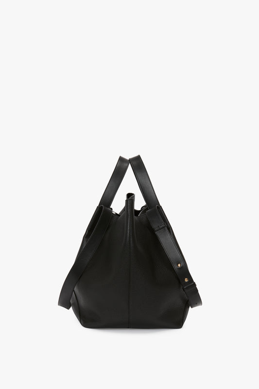 A W11 Medium Tote In Black Leather by Victoria Beckham, with two handles and a shoulder strap, featuring minimal gold hardware and crafted from luxurious grained leather for versatile styling.
