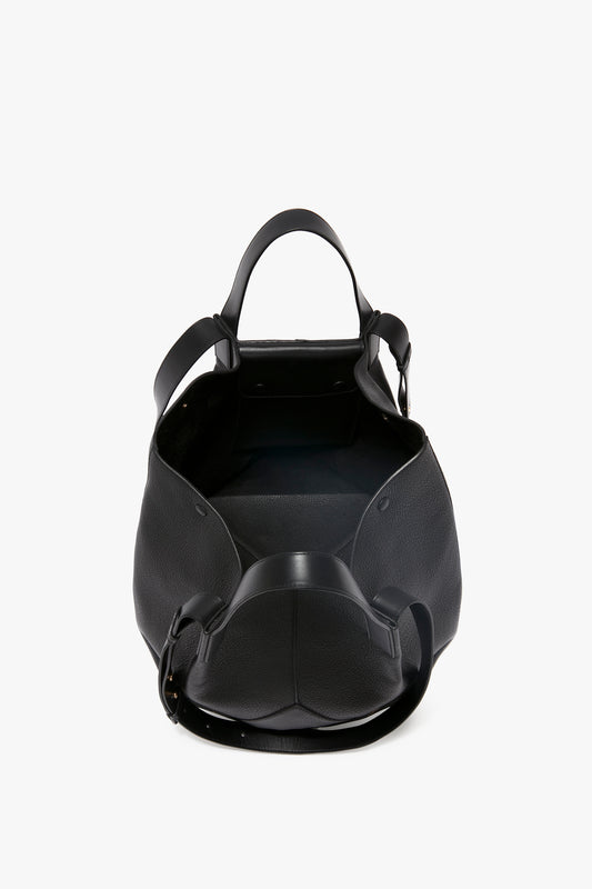 A spacious, open W11 Medium Tote In Black Leather by Victoria Beckham with two handles and a shoulder strap, crafted from luxurious grained leather, displayed against a white background.