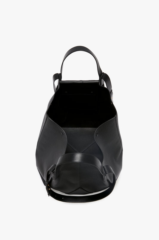 A Victoria Beckham W11 Jumbo Tote In Black Leather with a handle, adjustable straps, and spacious interior featuring an internal pocket compartment, viewed from the top.