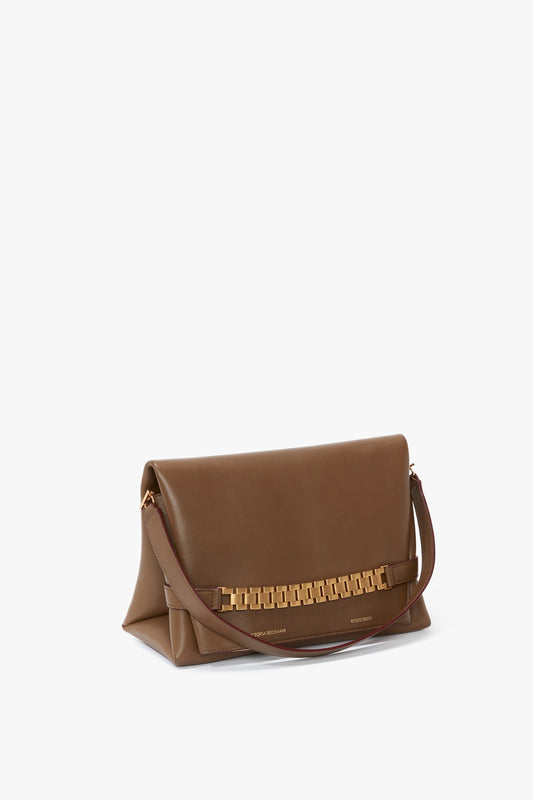 A khaki leather Chain Pouch Bag With Strap In Khaki Leather by Victoria Beckham UK features a chain-link embellishment and a slim, detachable strap.