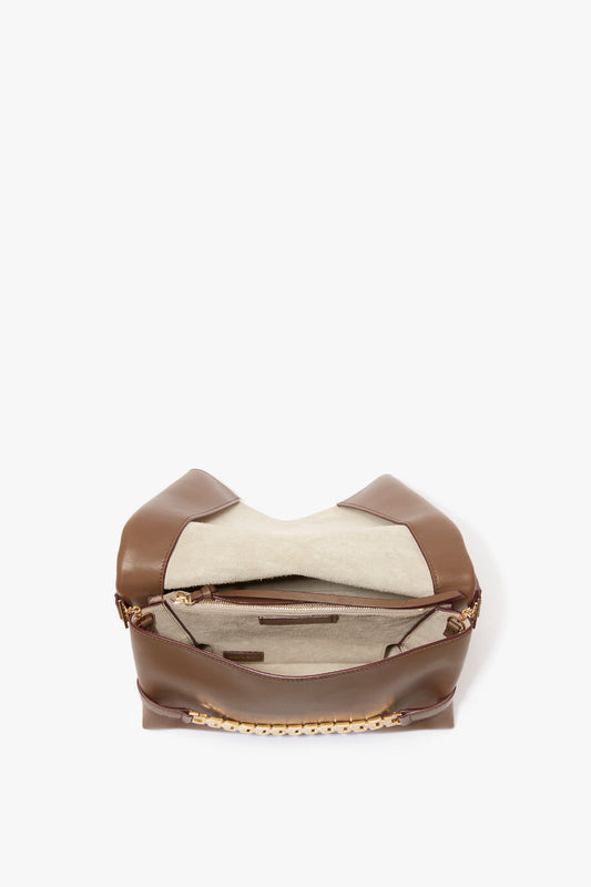 A Chain Pouch Bag With Strap In Khaki Leather by Victoria Beckham UK is open, revealing multiple compartments, a zipper pocket inside, and a detachable strap.