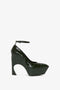 Victoria Beckham's Ankle Strap Wedge Pump In Dark Green Croc-Effect Leather features an embossed croc leather design and a sculptural curved cut-out heel; with a closed toe and an ankle strap.