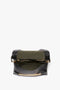 Open the Victoria Beckham Chain Pouch Bag With Strap In Black Croc-Effect Leather with a green interior, gold zipper, and gold chain detail at the bottom.