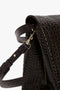 Close-up of a black textured leather handbag with a gold clasp, adjustable strap, and croc-effect chocolate brown leather detailing for versatile styling. The **Jumbo Chain Pouch Bag In Chocolate Croc-Effect Leather** by **Victoria Beckham** is designed to add elegance to any outfit.