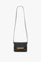 A small black Mini Chain Pouch Bag With Long Strap In Black Leather by Victoria Beckham with a long strap and gold hardware on the front flap.