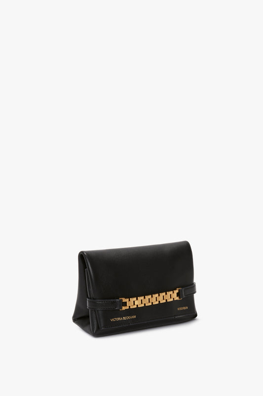 A Mini Chain Pouch With Long Strap In Black Leather, adorned with the words "Victoria Beckham" embossed in gold on the bottom right corner.