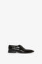 Victoria Beckham's Pointy Toe Flat Lace Up In Black Croc-Effect Leather with a polished finish and a lace-up design, featuring an embossed croc calf leather texture pattern, set against a plain white background.