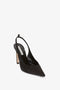 The Victoria Beckham Pointy Toe Satin Sling Back Pump In Black features a slingback strap, pointy toe, and a medium-block heel.