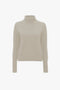 A Victoria Beckham polo neck jumper in ivory displayed against a white background.