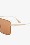 Close-up of Rectangular Visor Gold-Framed Sunglasses featuring caramel lenses, showing a side view with the engraved Victoria Beckham logo on the temple.