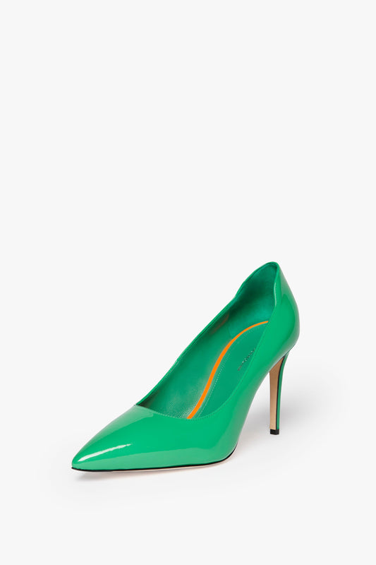 A single jade green patent leather high-heeled shoe with a pointed toe on a white background. The VB 90mm Pump In Jade by Victoria Beckham showcases a 90mm stiletto heel and a glossy finish, exuding elegance and sophistication.