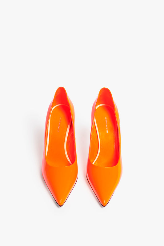 A pair of Victoria Beckham VB 90mm Pump In Fluorescent Orange with pointed toes and a 90mm stiletto heel, viewed from above against a white background.