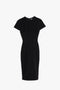 A Fitted T-Shirt Dress In Black by Victoria Beckham with a high neck and knee-length hemline displayed against a plain white background.