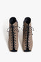 A pair of Reese Boots In House Monogram Jacquard by Victoria Beckham in beige, featuring a monogram print and peep toe design, viewed from the front.