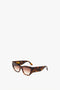 A pair of Victoria Beckham Sculptural Frame Sunglasses In Dark Havana Fade with tortoiseshell acetate frames and brown gradient lenses on a white background.