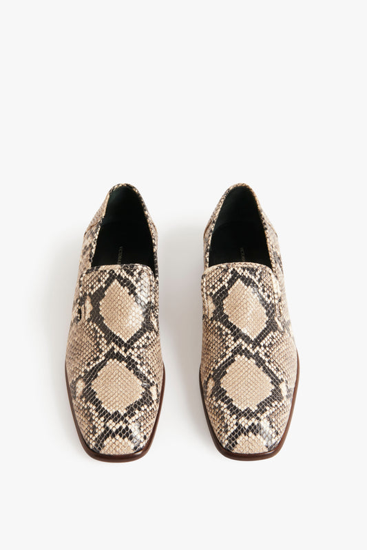 Introducing the Victoria Beckham Hanna Loafer in Beige Snake Print: a pair of classic loafers featuring a stunning beige snake print with a black and beige diamond design on a white background.