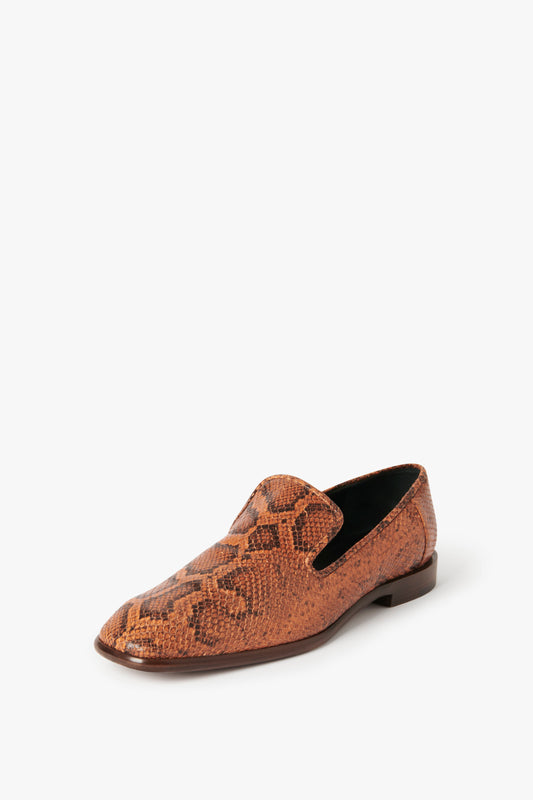 A single Victoria Beckham Hanna Loafer in Copper Snake Print with a low heel is displayed against a plain white background, embodying the elegance of the Spring Summer 2022 collection.